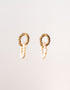 Pair of gold hoop earrings with pearl-like beads on a light background