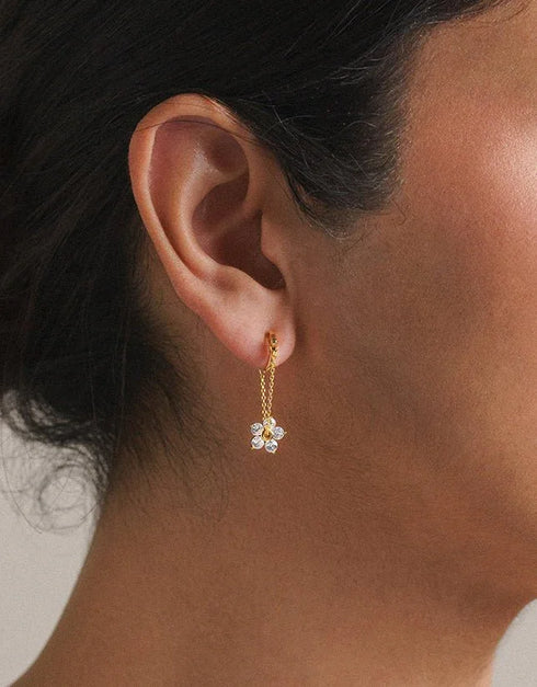 gold pierced drop earrings with chain and flower-shaped clear gemstones, elegant feminine style
