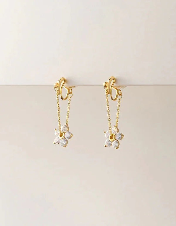 Gold pierced drop earrings with delicate chain and sparkling gemstone flower charms, elegant feminine style