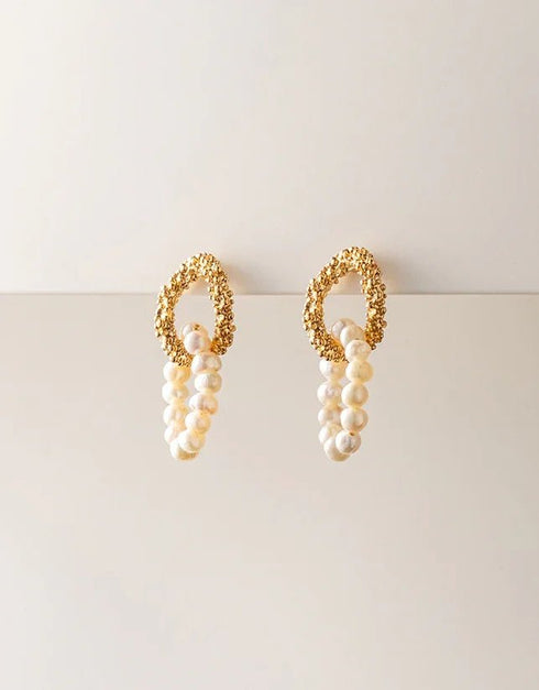gold textured hoop earrings with hanging white pearl strands, elegant statement pierced jewelry