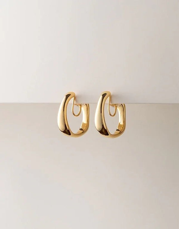 Gold polished hoop earrings with thick, curved design, modern minimalist style jewelry