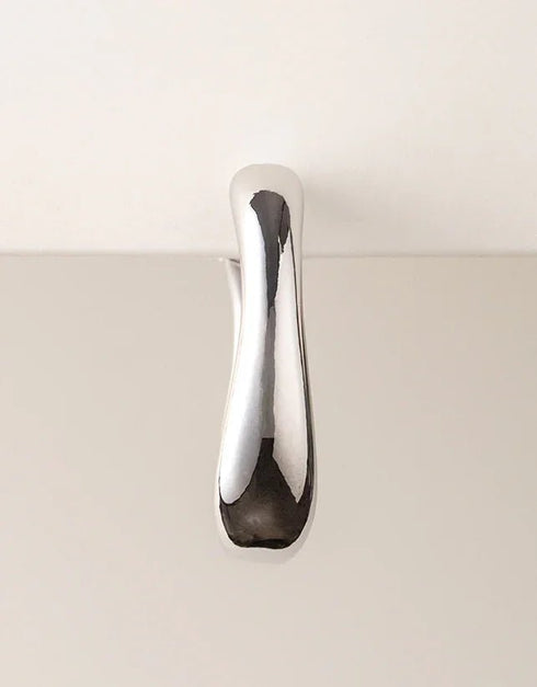 Modern silver hoop earring with wide, contoured smooth finish, minimalist style pierced jewelry