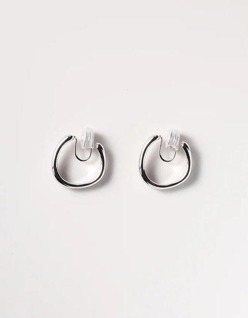 Silver irregular hoop earrings with polished finish and clear plastic backing, minimalist modern style