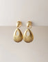 Gold-tone pierced drop earrings with textured, open teardrop shape and polished finish, elegant statement style