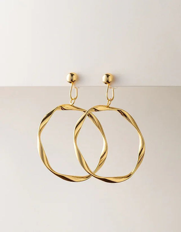 Gold twisted hoop earrings with polished finish and geometric organic shape, elegant modern jewelry style